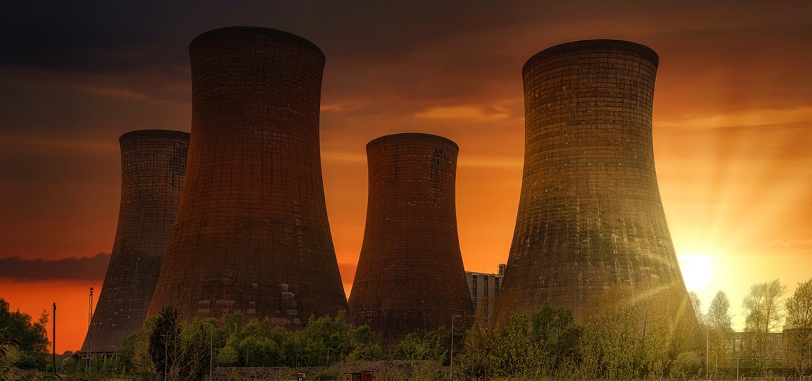 4 Huge cooling towers in nuclear power plant in the sunset