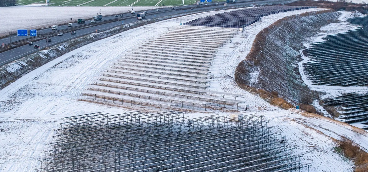 agrivoltaics (Agri-PV) plant on the field coverd with snow, next to a highway