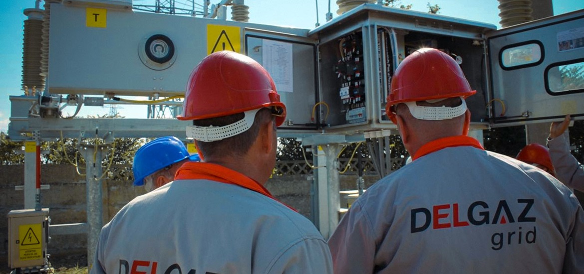 Delgaz Grid workers looking inside the pole utility transformer on the site