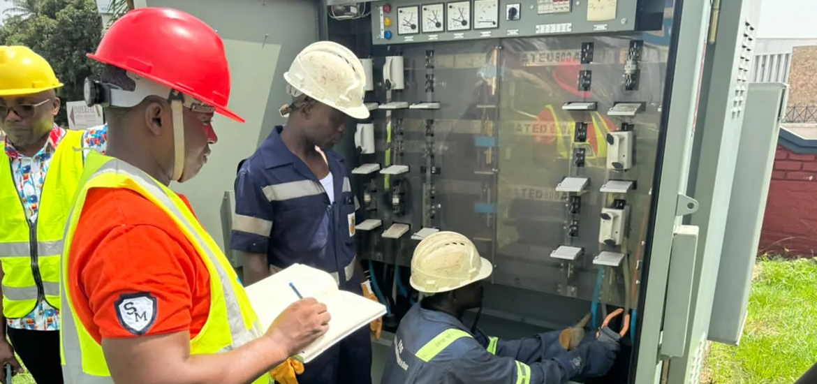 4 maintenance workers inspecting a transformer