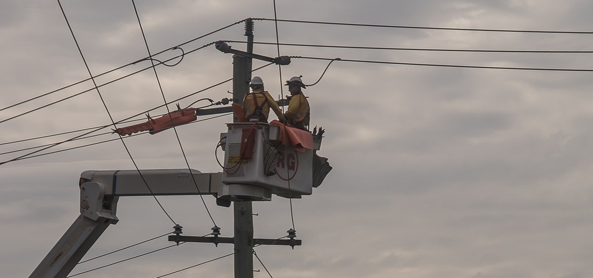 two maintenance workers working on the power pole