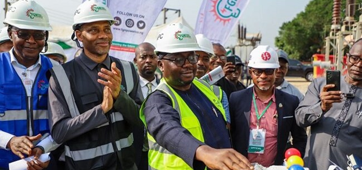 Nigerian Minister of Power surrounded by ingineers and other audience, standin at the substation