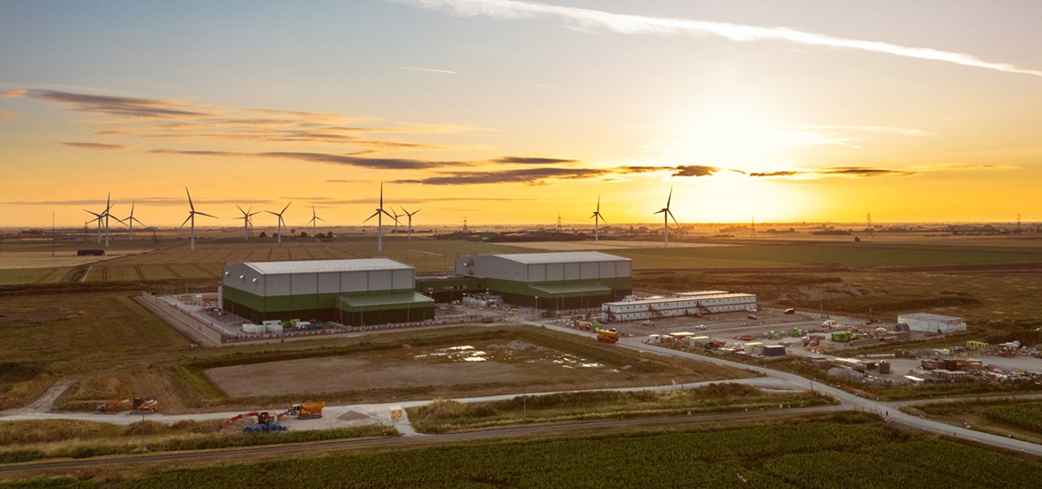 Wind farm and storage facilities in the field in the sunset 