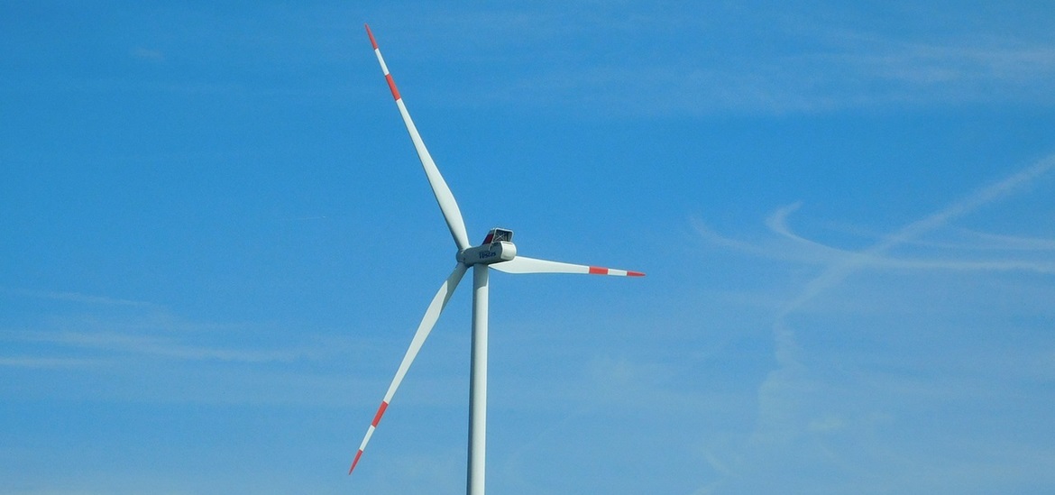 Windmill turbine against blue sky