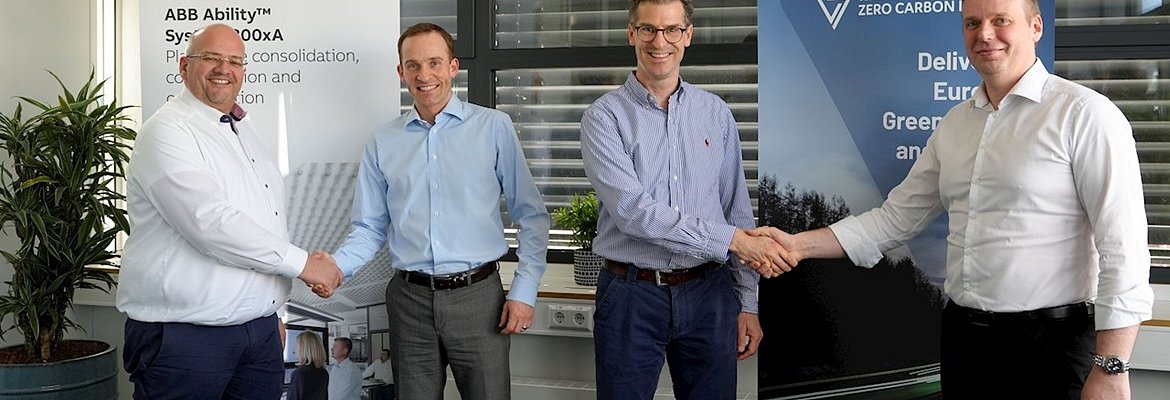 2  ABB representatives shaking hands with 2 Vulcan Energy representative in front of company banners, smiling to the camera