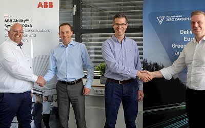 2  ABB representatives shaking hands with 2 Vulcan Energy representative in front of company banners, smiling to the camera